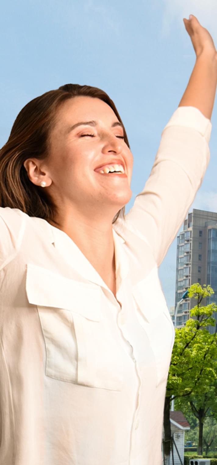 Woman with eyes closed and arms raised in happiness