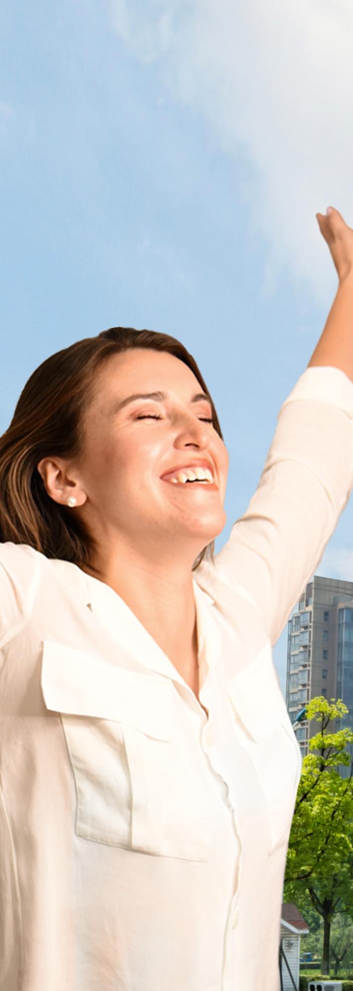 Woman with eyes closed and arms raised in happiness